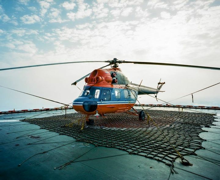 a helicopter on the ground near the water