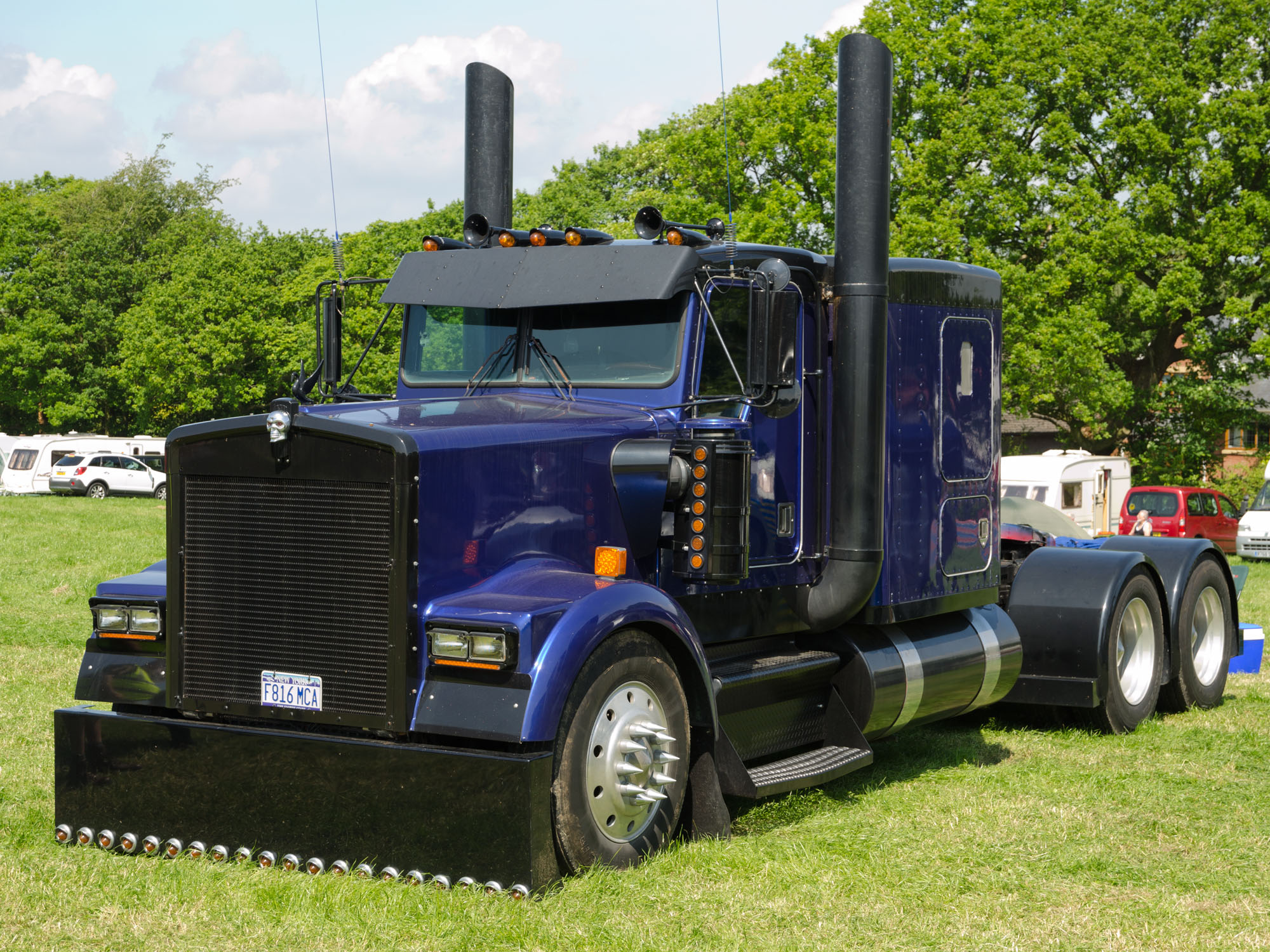 a large blue truck is sitting in the grass