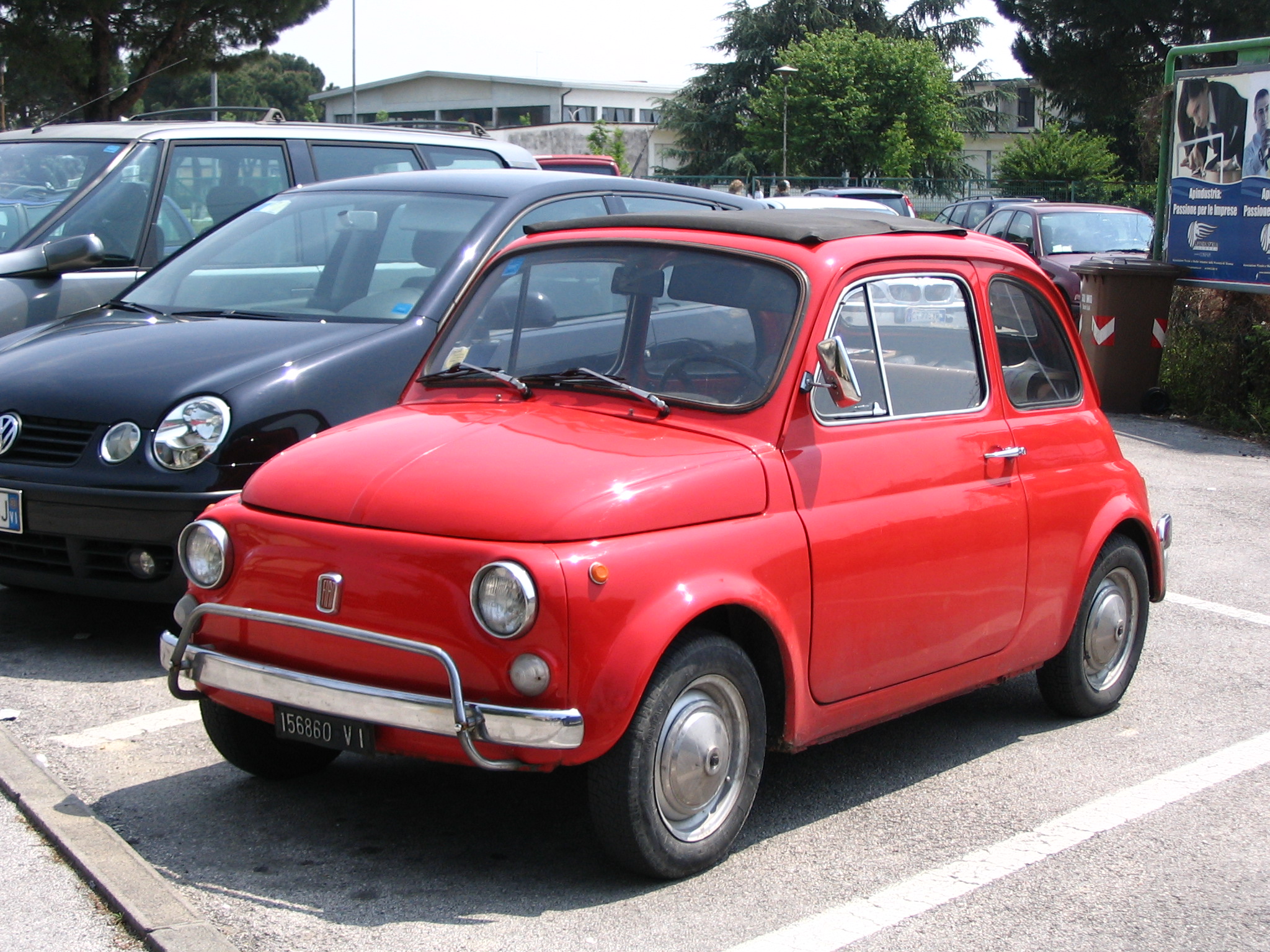 a red car is parked near two other cars