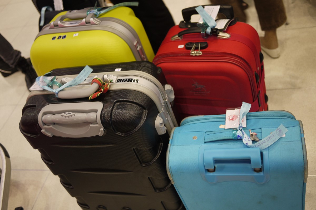 many pieces of luggage lined up on the ground