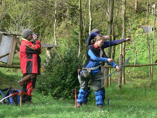 people on a field using their bows and arrows