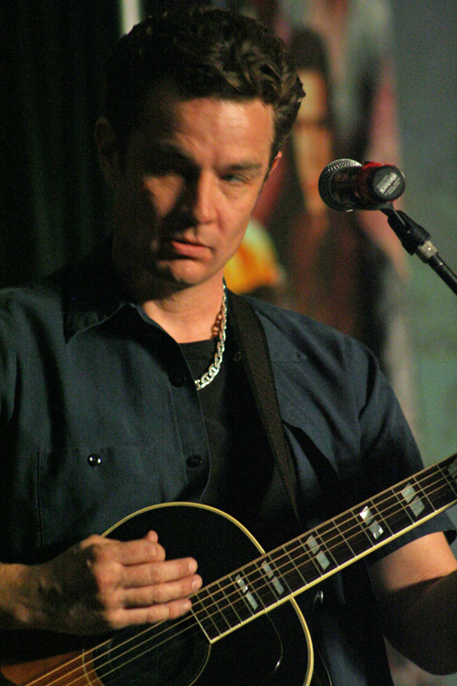 a man playing guitar on stage at a concert