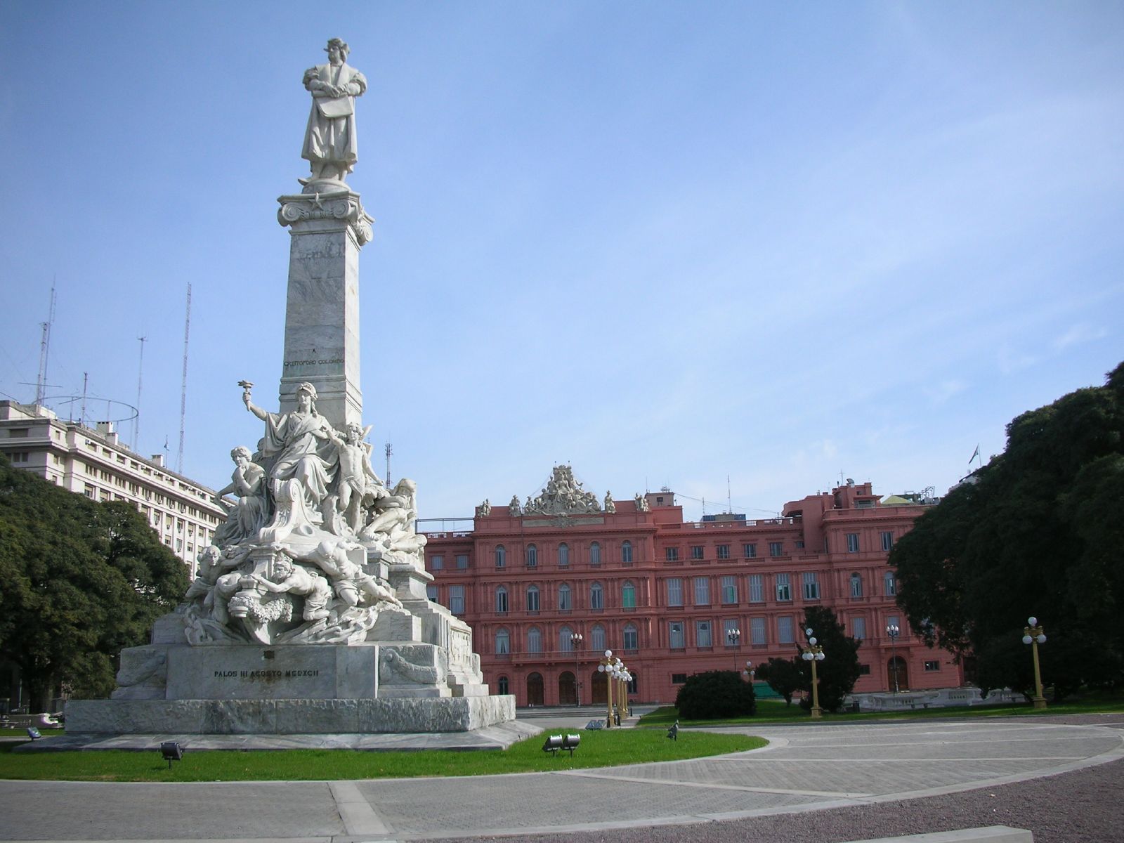 the statue is outside of a large red building