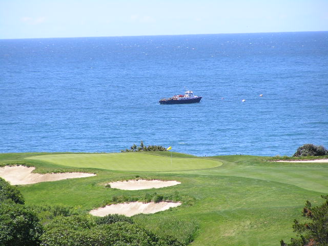 a boat in the ocean is docked at the top of a golf course