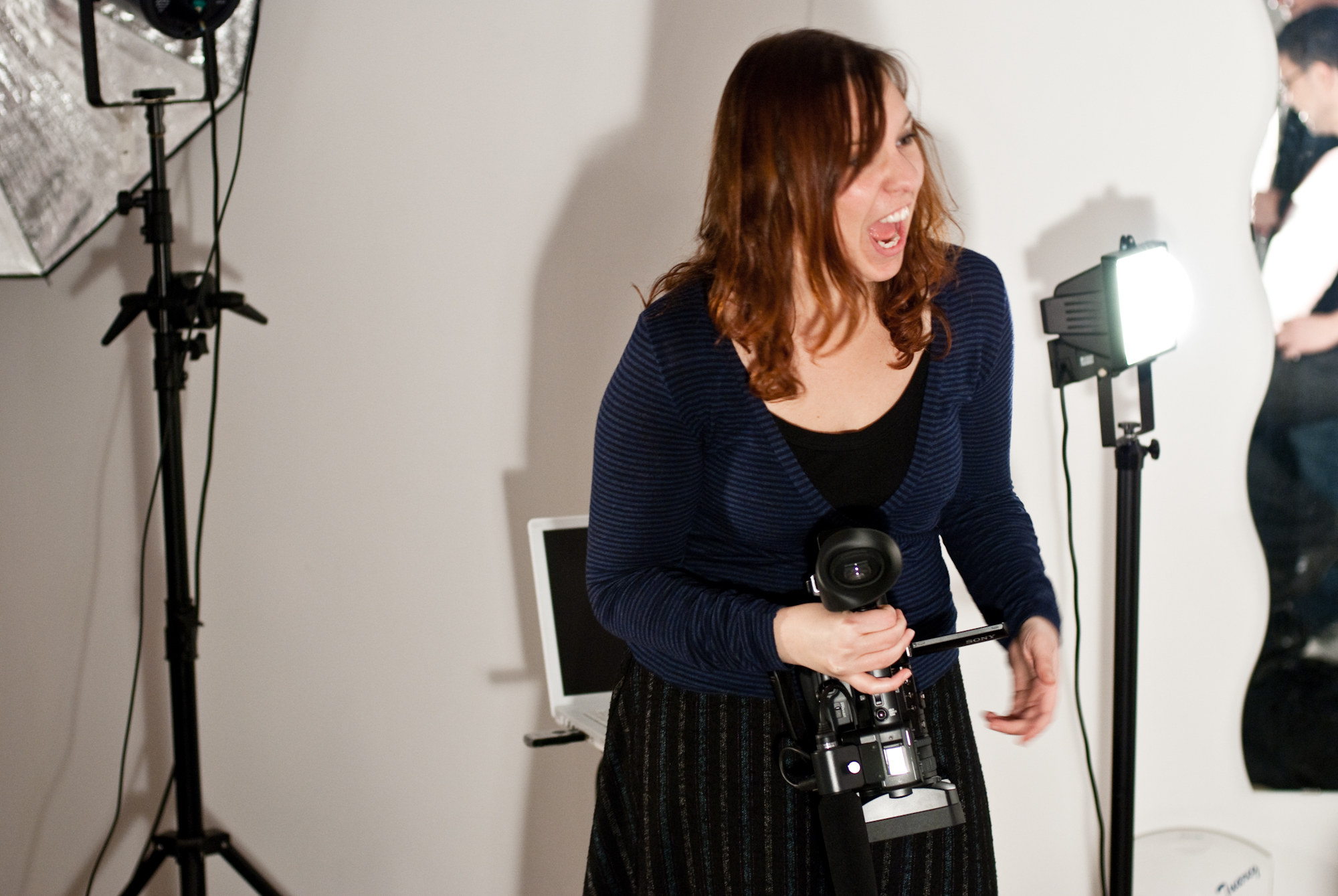 the woman is laughing while holding a video camera