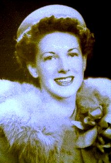 a woman smiling at the camera with fur on her shoulders