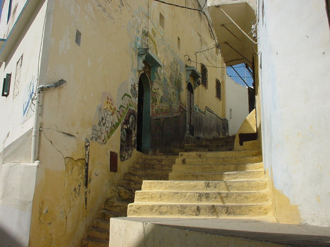 a street has stairs and graffiti painted on the side of the building