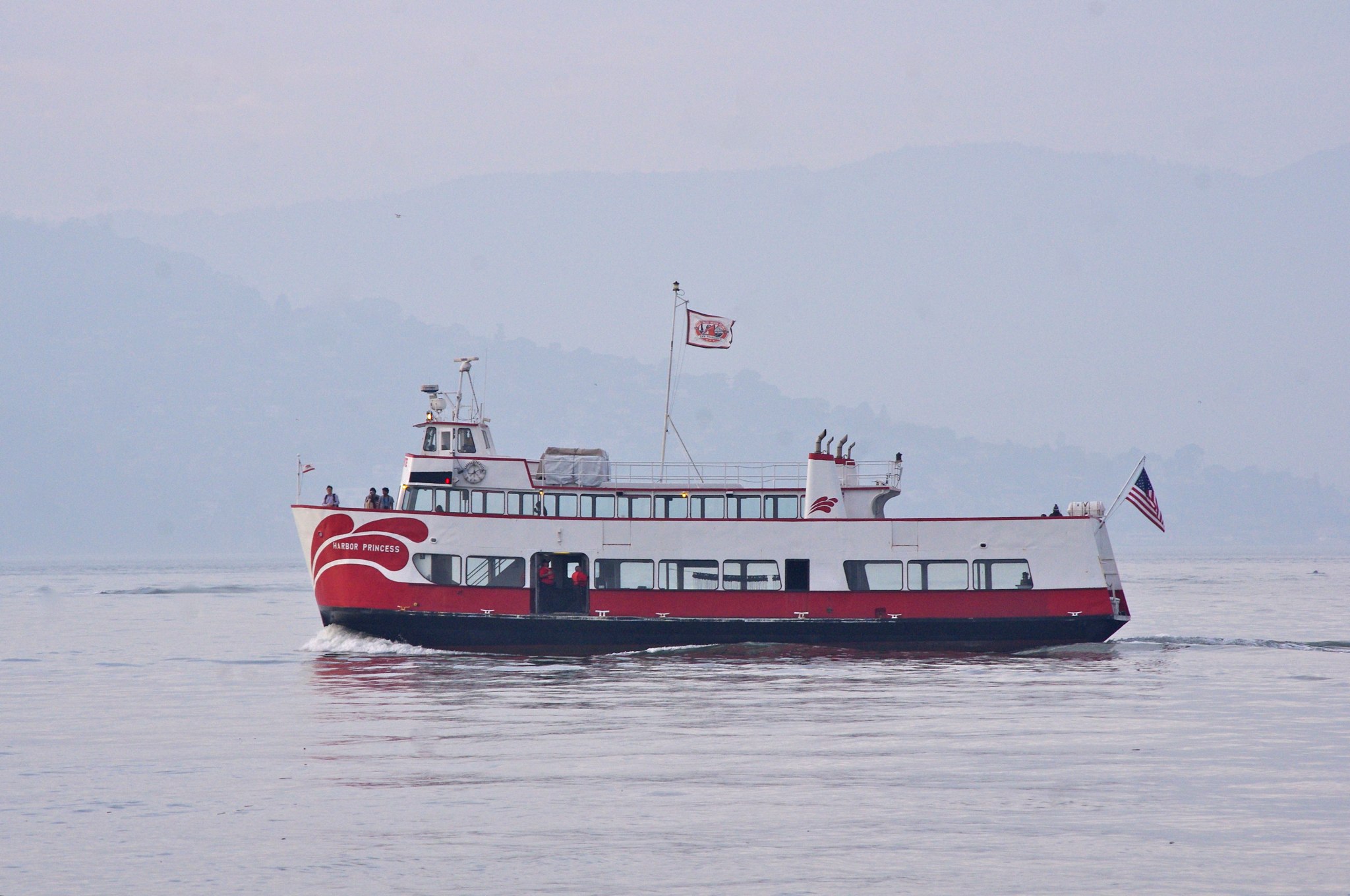 a red and white passenger ferry sailing on the water