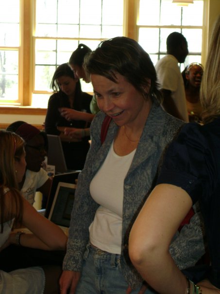 the woman smiles as she looks at a cell phone