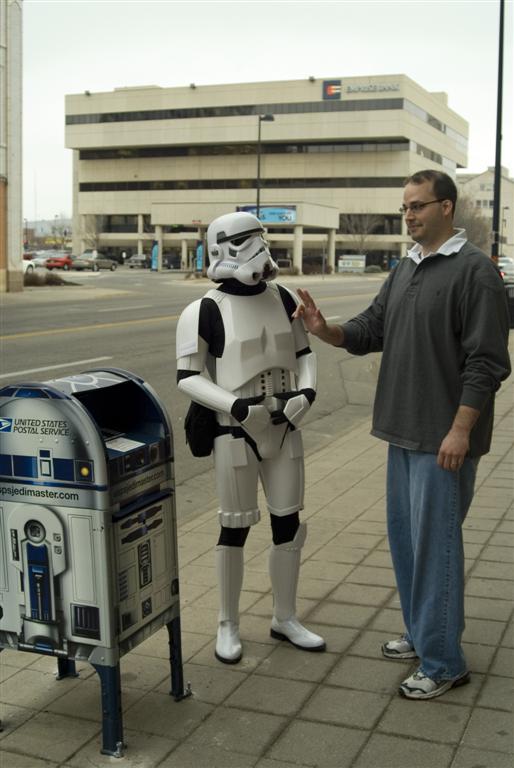 a man wearing a star wars costume standing next to a mailbox