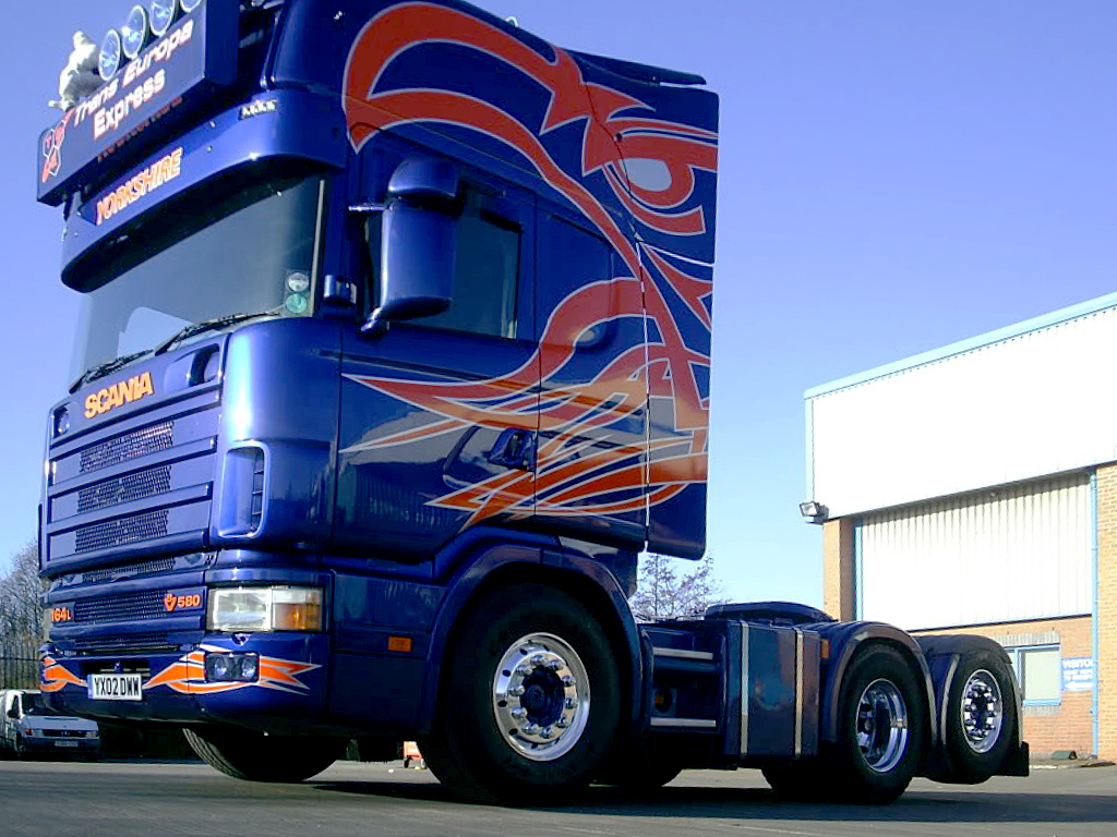 the large truck is painted blue with colorful designs