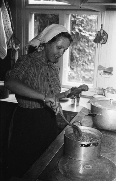 an old black and white po shows a woman preparing food