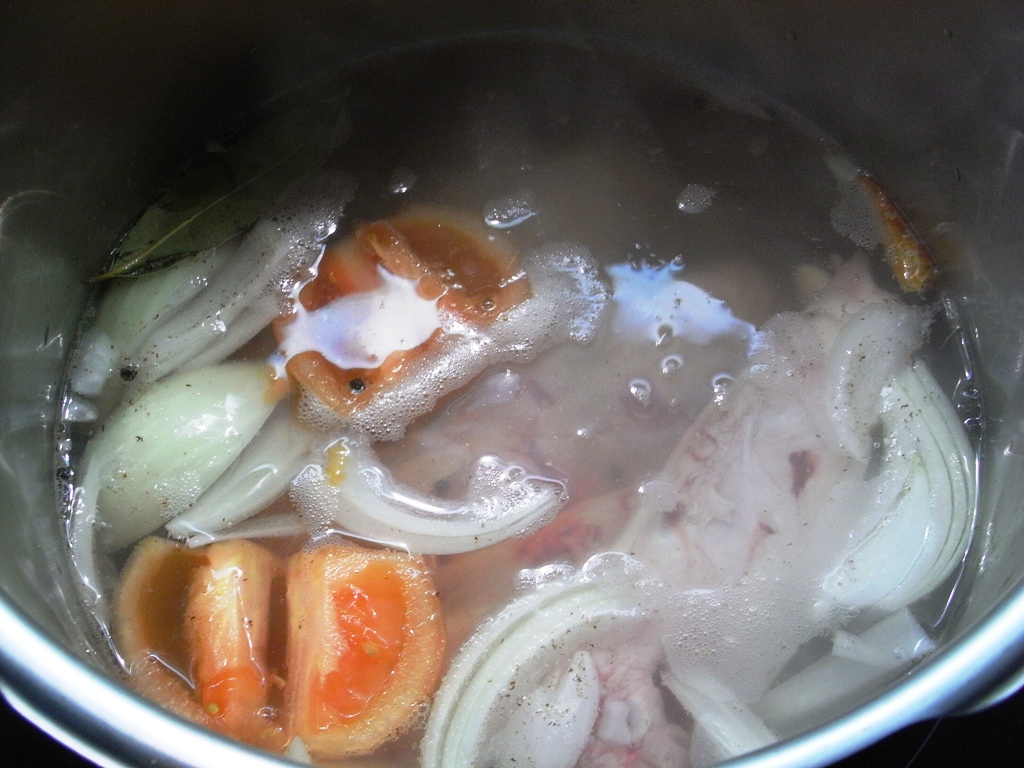 carrots, onions, and other vegetables in a pot full of boiling water