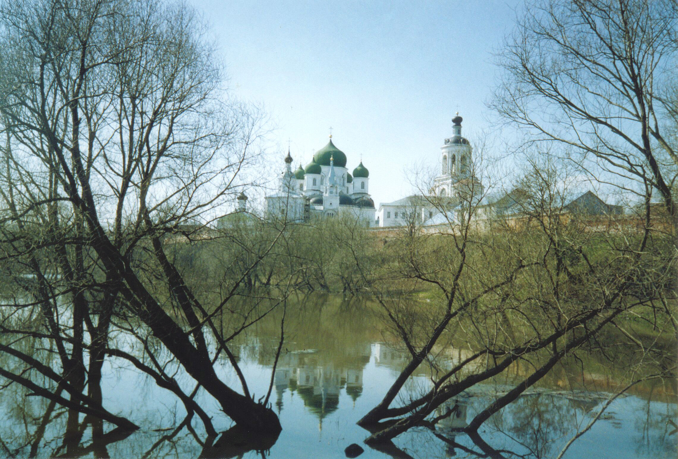 a lake in a park with trees and a cathedral