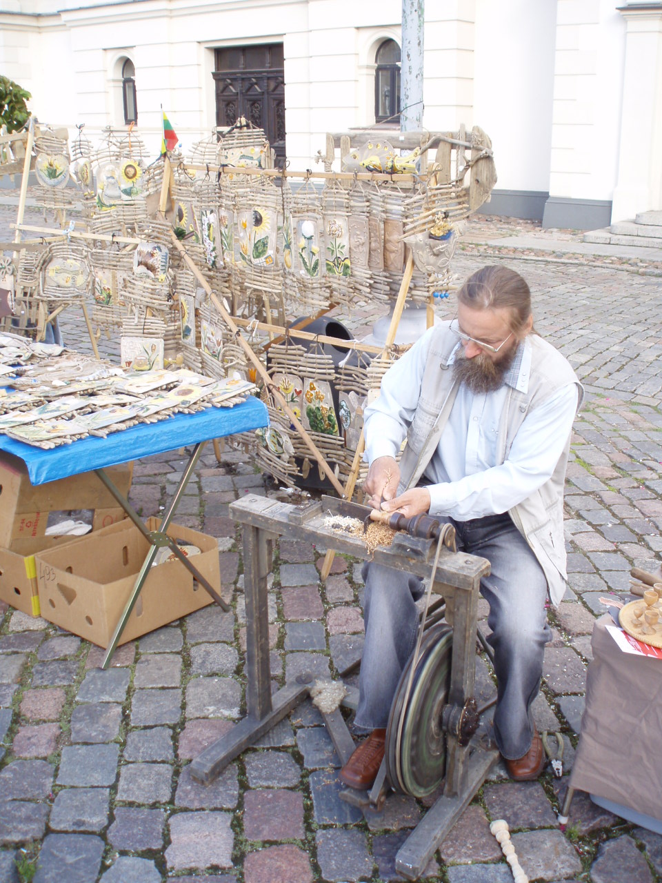 a man working with wooden things outside on his bike