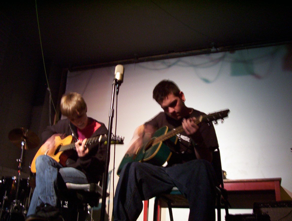 people with instruments sitting at a stage