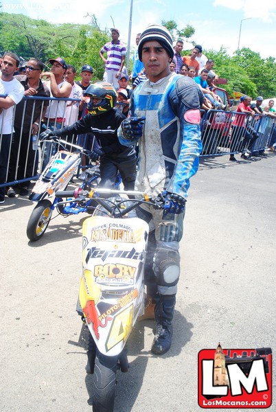 a man in a blue suit standing next to his motor cycle
