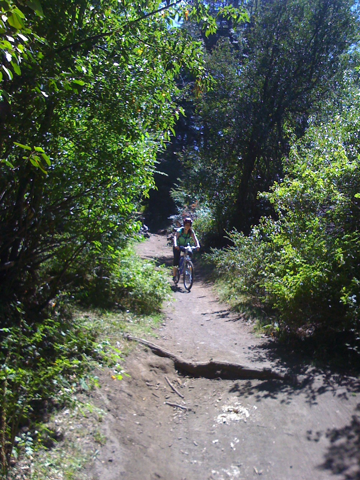 a woman rides her bike on a dirt trail