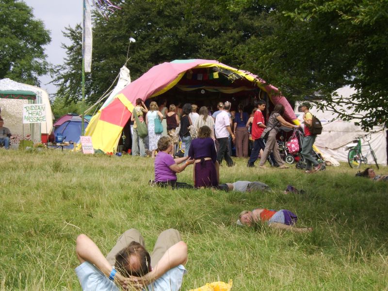 a crowd of people sitting on top of a grass covered field