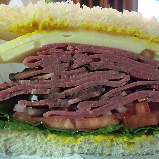 a sandwich that includes meat, cheese and lettuce