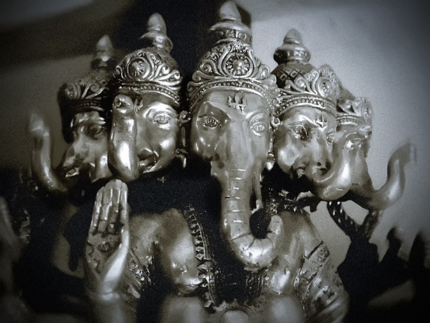 two silver ganjutti figurines on the table