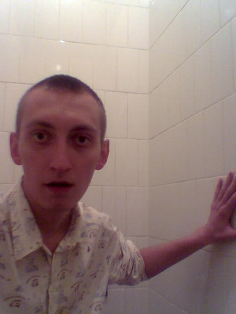 a man is posing for the camera in front of a tiled shower