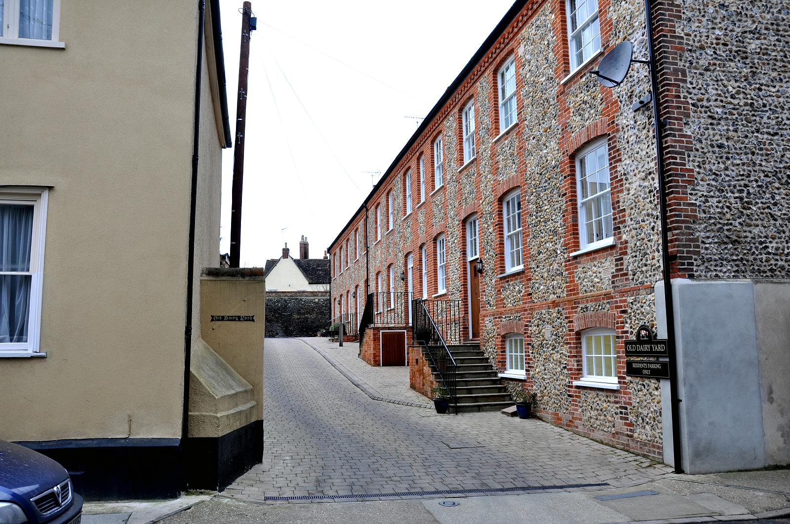 an alley leading to two buildings with brick on the sides