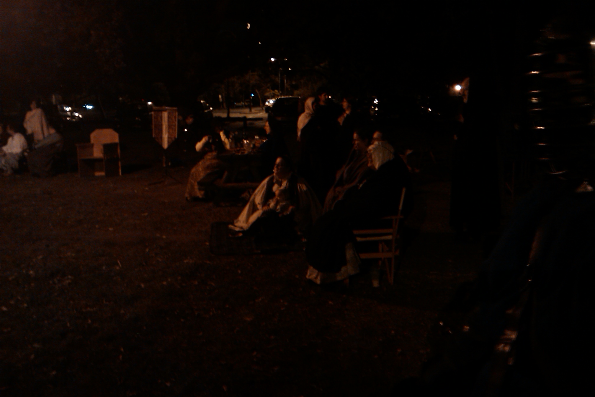 people sitting on lawn chairs at night in the dark