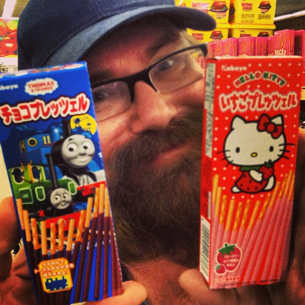 the man is holding up two hello kitty matches boxes