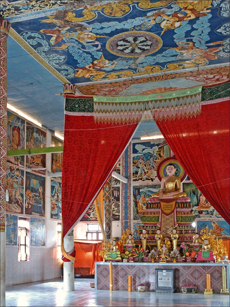 a large buddha statue with many paintings on the walls and ceiling