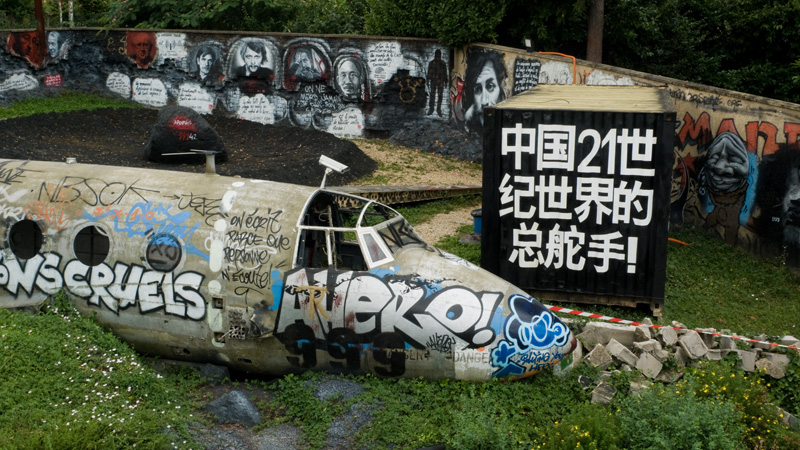 an abandoned plane that has been placed near some graffiti