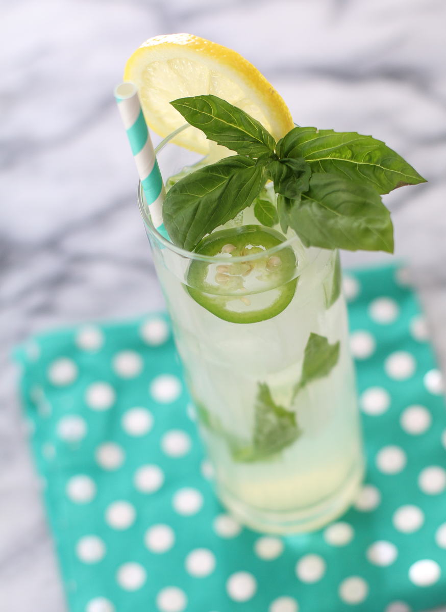 a close up of a drink with a lemon wedge and mint on it