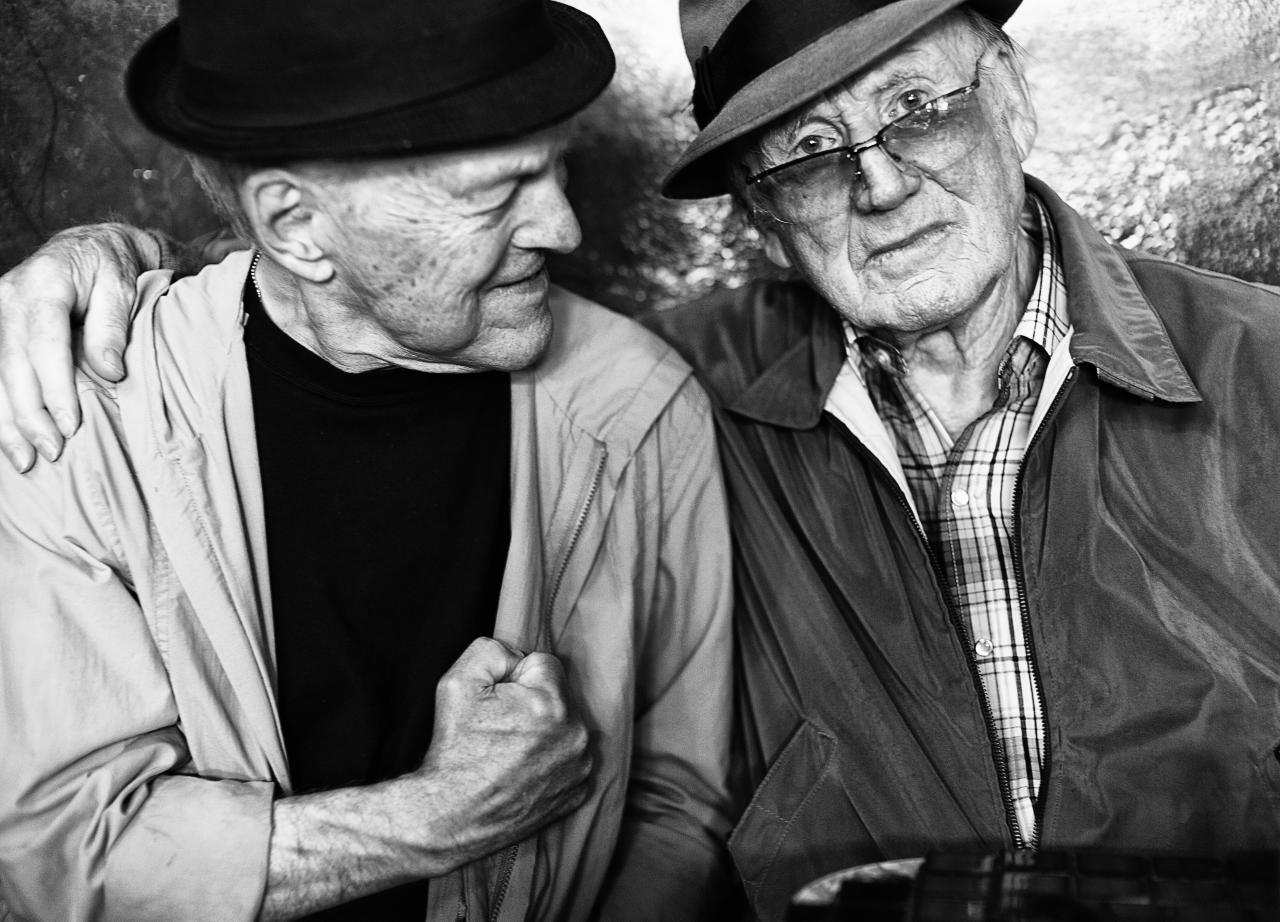 a couple of elderly men standing next to each other