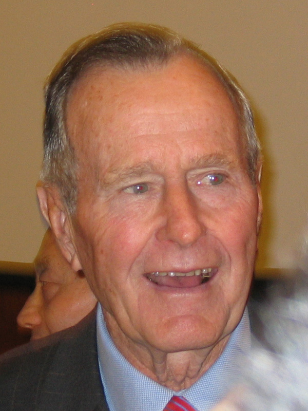 a older man wearing a suit and tie