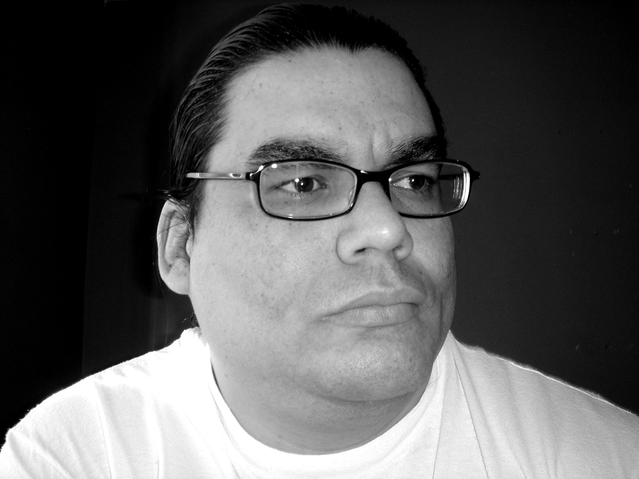 a man wearing glasses with short hair looks off to the right