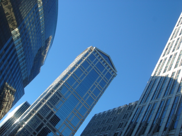 two tall skyscrs against the sky on a sunny day