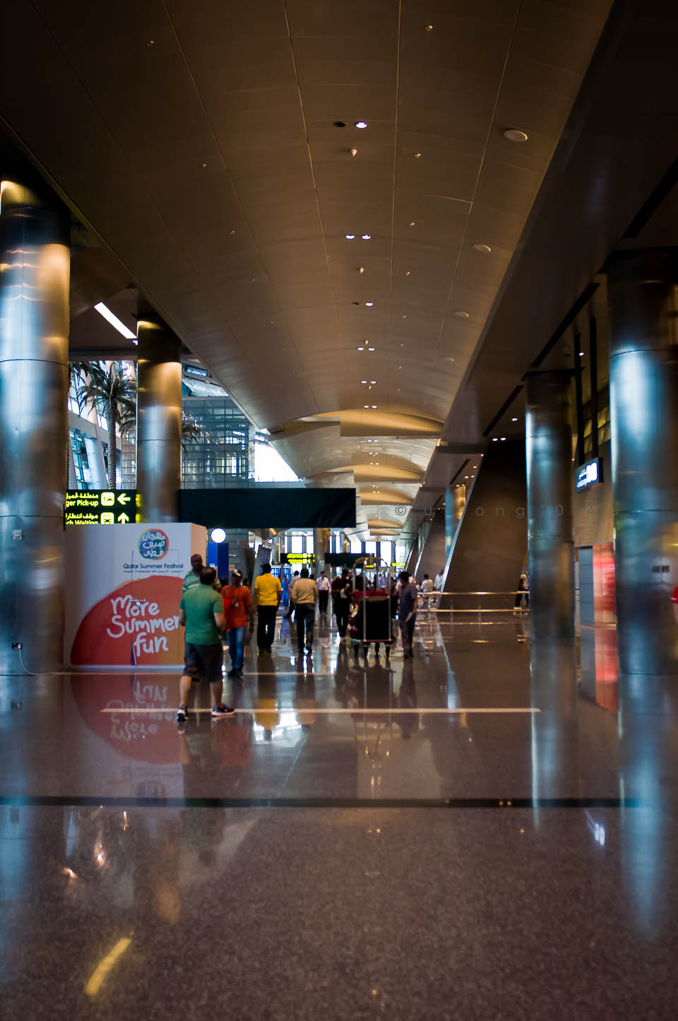 a line of people walking inside of an airport