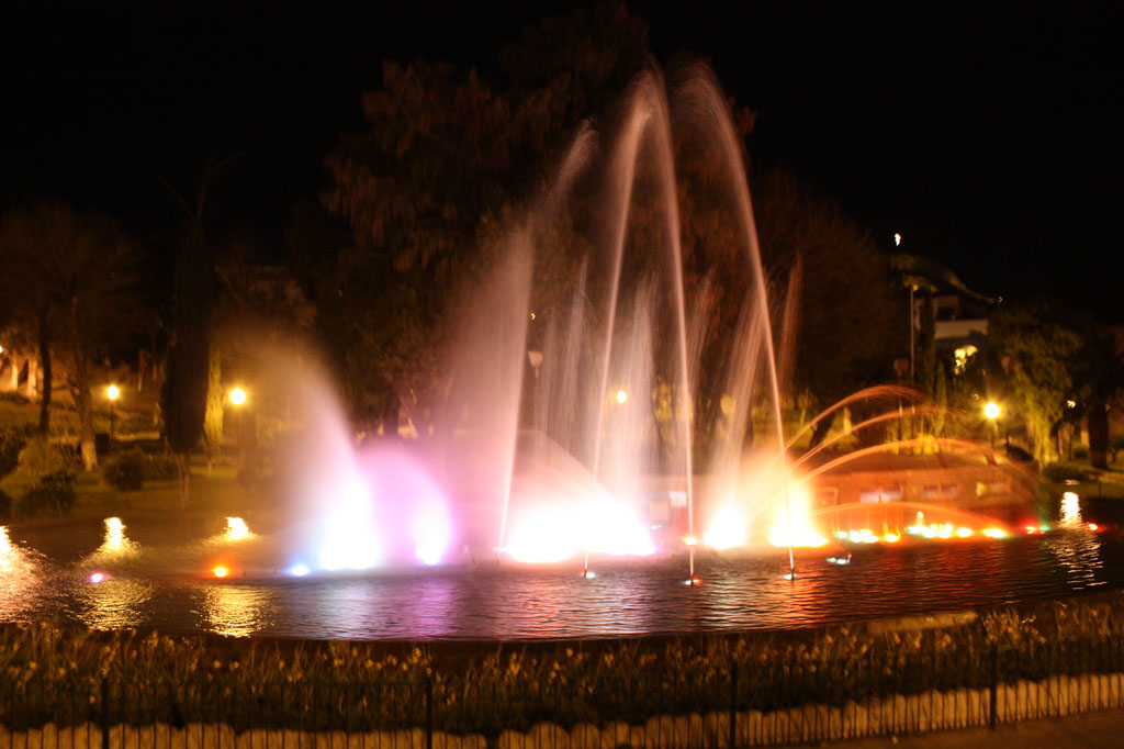 a large fountain with colorful jets on the water