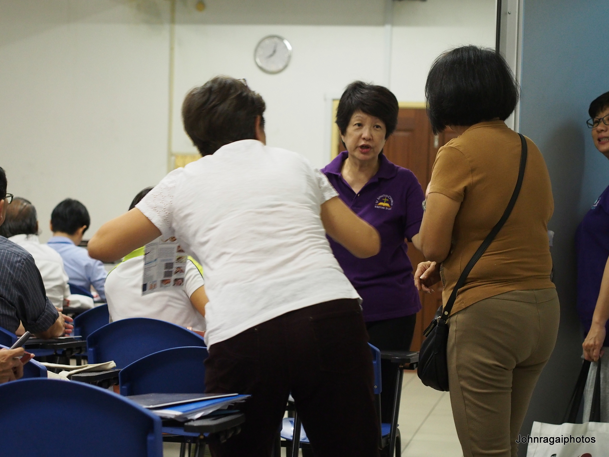 three woman at an event with one pointing to the other