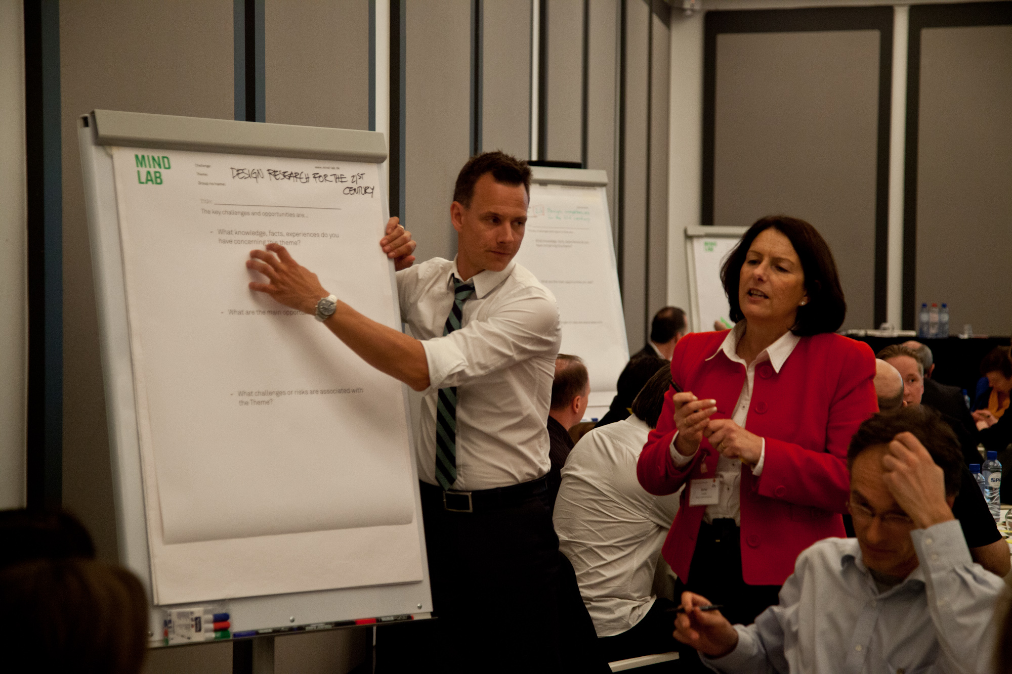 some people in a meeting room and one person standing up