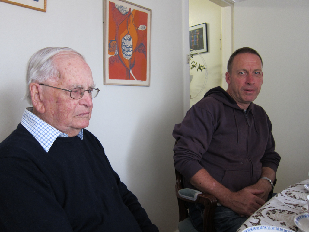 two older men sit together at a dining room table