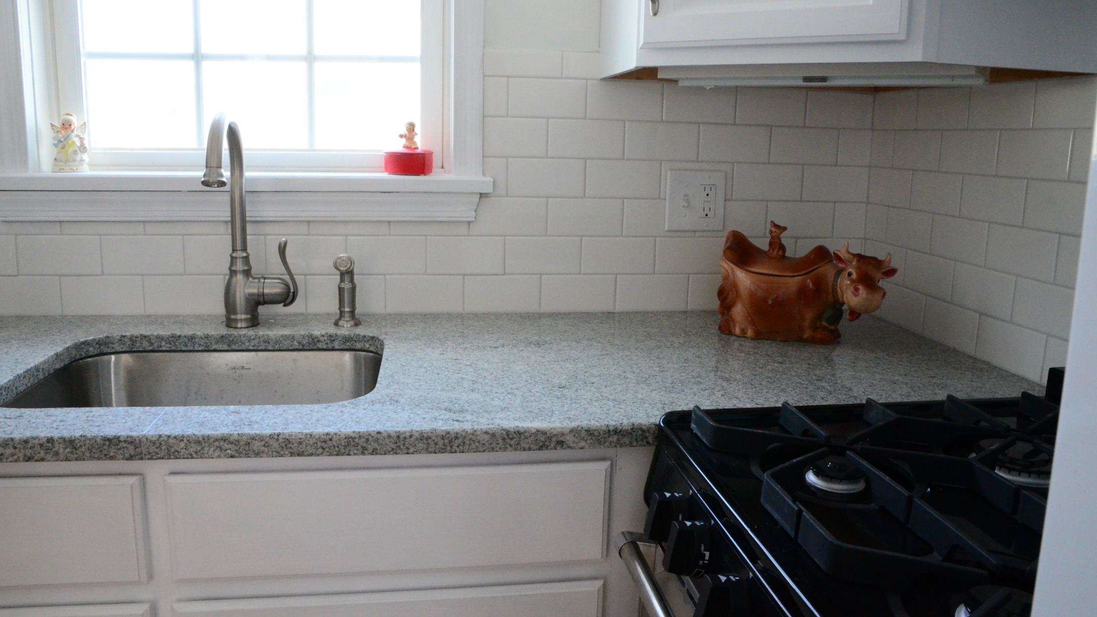 the kitchen sink has two faucets and a stove top oven