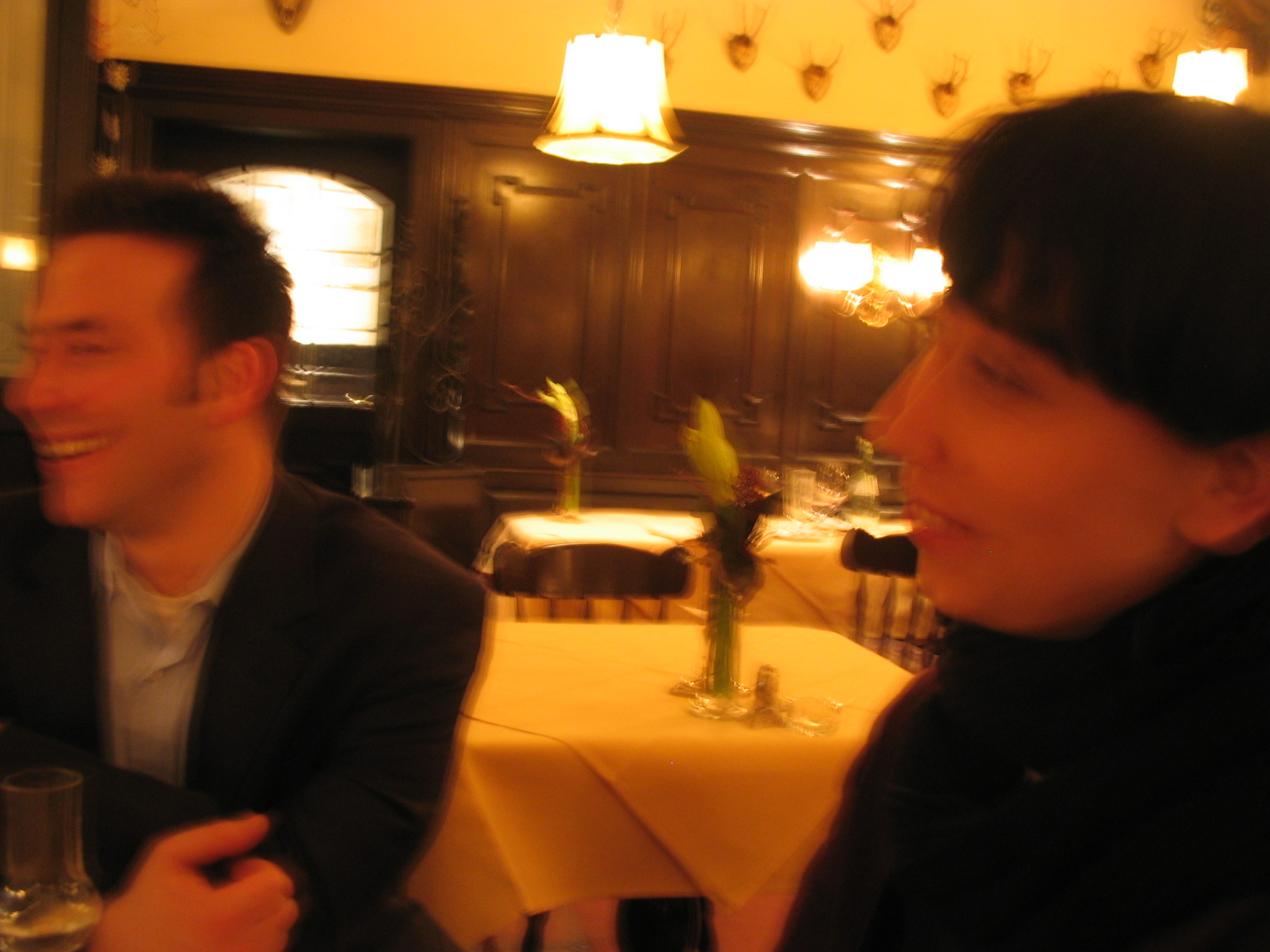 two women smiling in a restaurant with some chairs