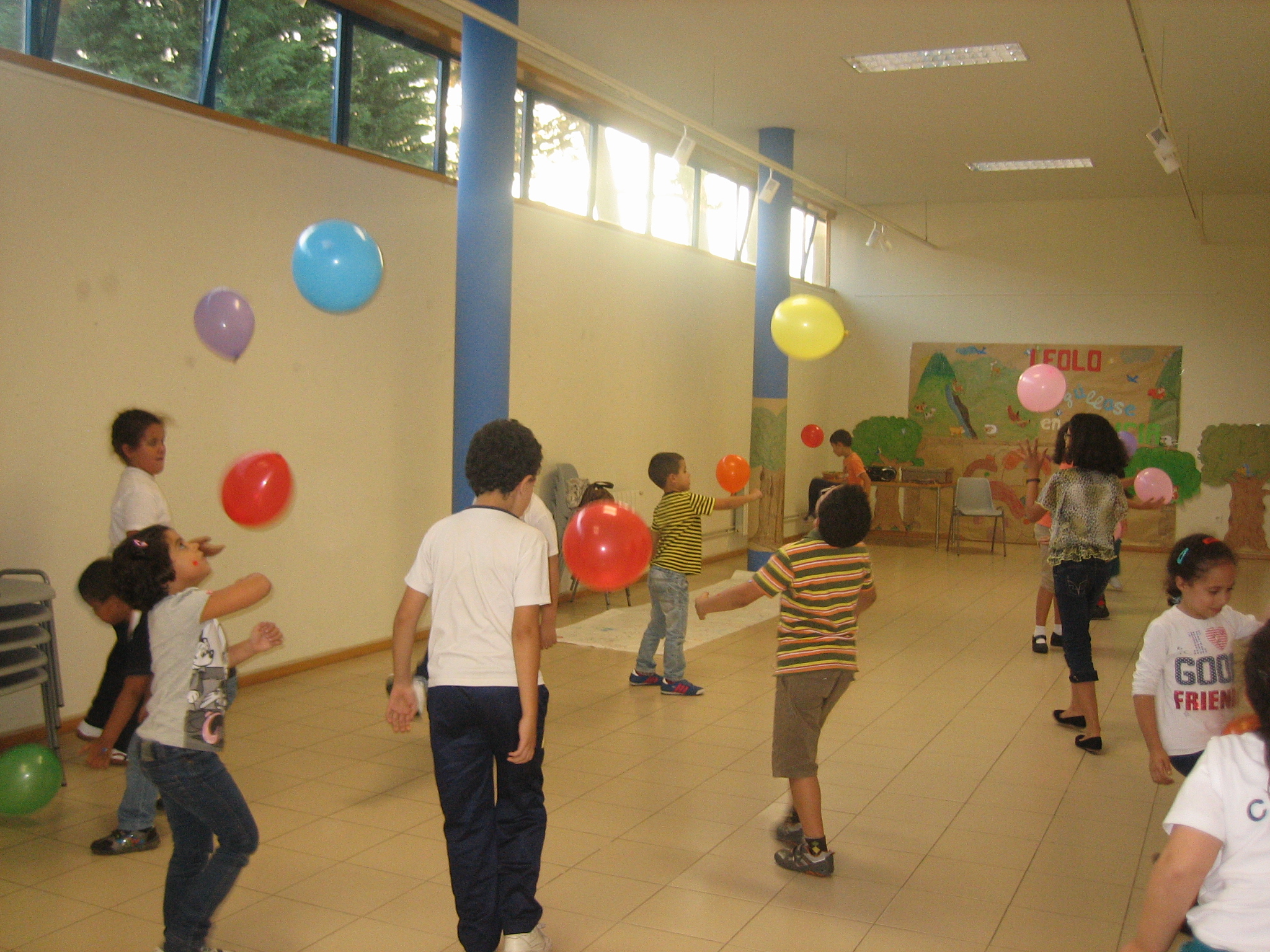 a group of s holding up balloons in a room