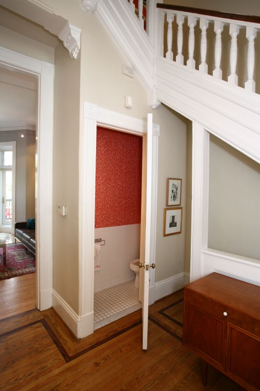 a hallway with an open closet and a small bench