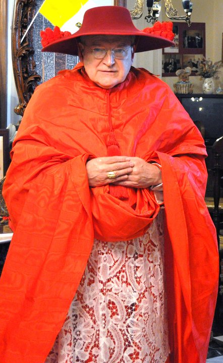 an older woman in a red cape standing next to some pictures