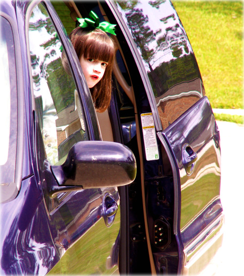 a girl sitting in the driver's seat of a car