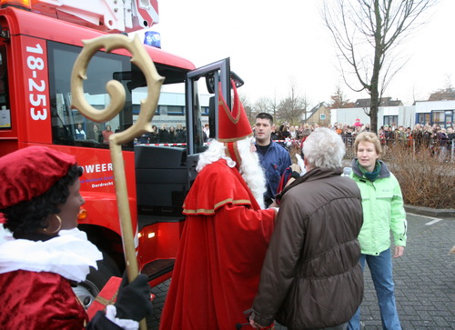 a crowd of people standing near a bus and a christmas decoration