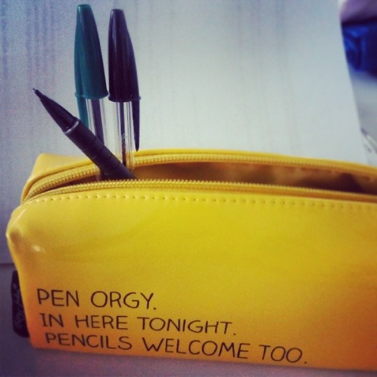 three pens are sitting in an old purse