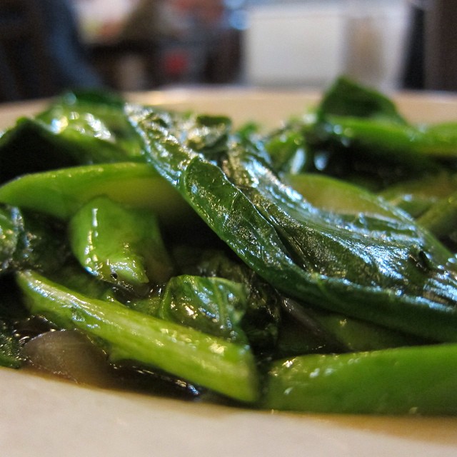 green vegetables are cooking on the plate and sitting on the table